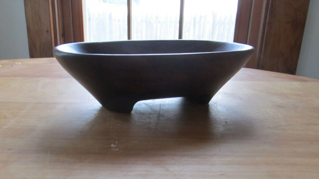 A carved wooden bowl on a table.